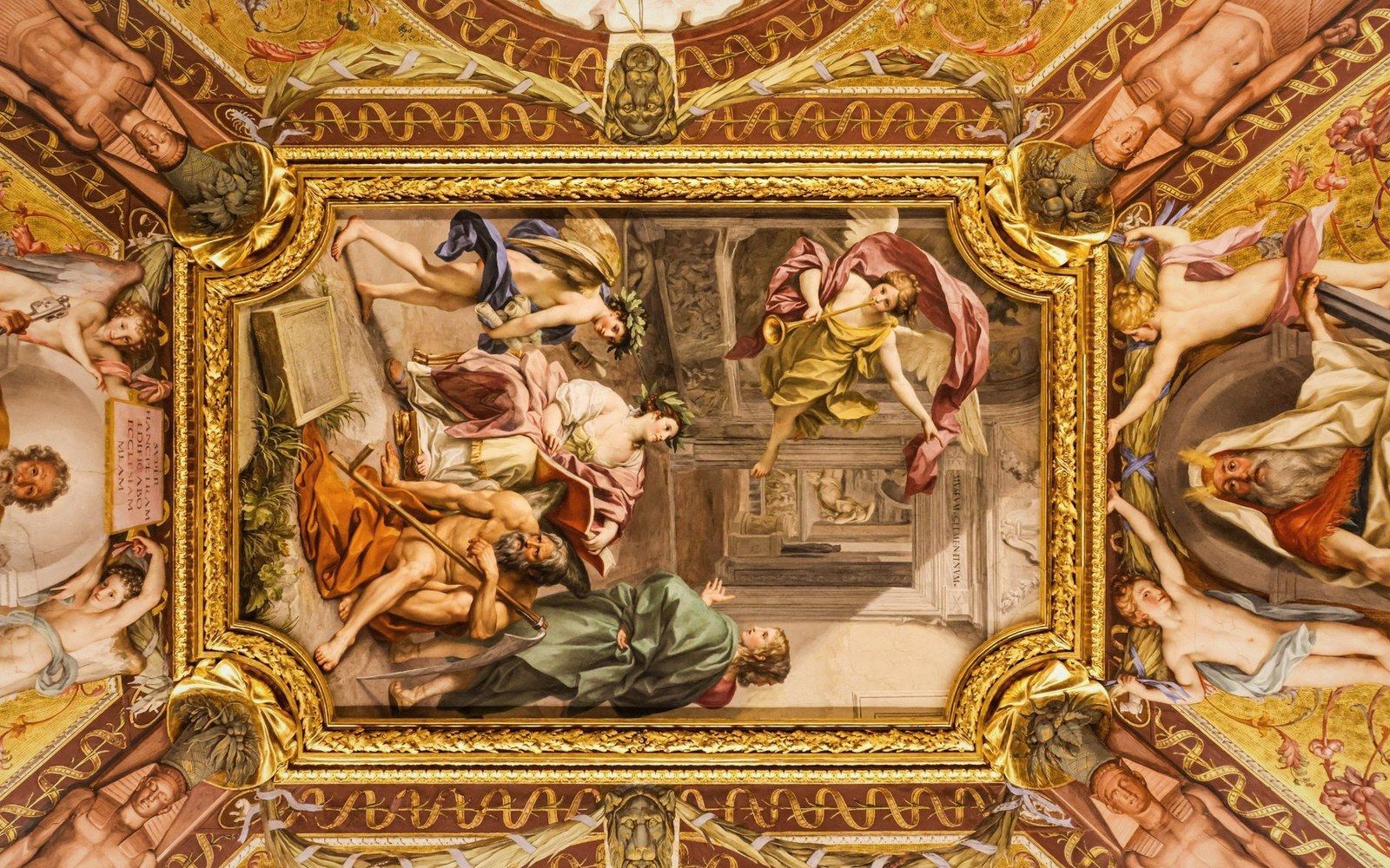 A gilded ceiling fresco of robed figures and a winged angel, framed in ornate baroque molding